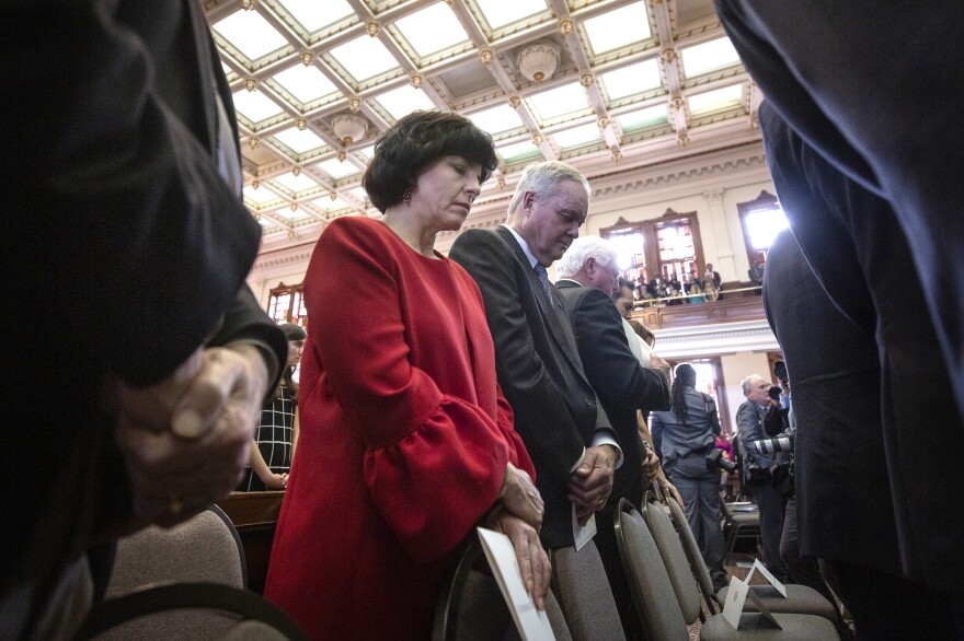 Christi Craddick (center), and Wayne Christian (right) of the Texas Railroad Commission bow their heads in prayer at the opening of the 86th Texas legislative session on Jan. 8, 2019, at the state capitol in Austin.