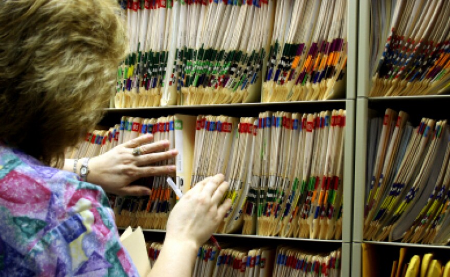 A nurse looks for medical records.