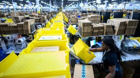 A woman works at a packing station in Amazon's fulfillment center in Staten Island. (Johannes Eisele/AFP via Getty Images)