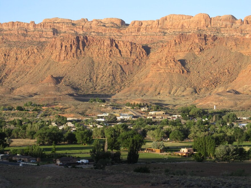 A view of the town of Moab set against red rock cliffs