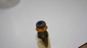 A prosthetic eye sits and dries on a stand