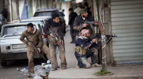 Syrian rebels take position during clashes with government forces in Idlib, north Syria.