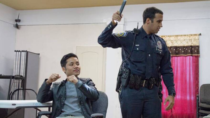 Officer Randy Diaz, one of just two members on IMPD's Immigrant Outeach Unit, runs through a mock traffic stop for an audience of Burmese immigrants.