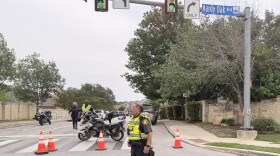 San Antonio police officers block access to Hardy Oak Boulevard near Red Hawk Ridge during a June 19, 2026, standoff in the Stone Oak area. SAPD says a domestic violence shooting left two people dead and an officer wounded.