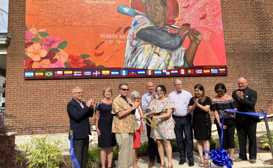 Guests, elected officials, community members and other attendees celebrate the unveiling of "De Boriken, al Mundo" June 10 at the Hispanic Center Lehigh Valley.