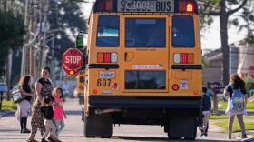 Children disembark from a school bus in a largely Hispanic neighborhood that has been the subject of patrols and detentions by Border Patrol agents, during a federal immigration crackdown in Kenner, La., Wednesday, Dec. 10, 2025. (AP Photo/Gerald Herbert)