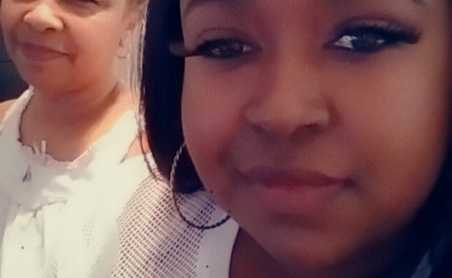 Two black women smiling into the camera.