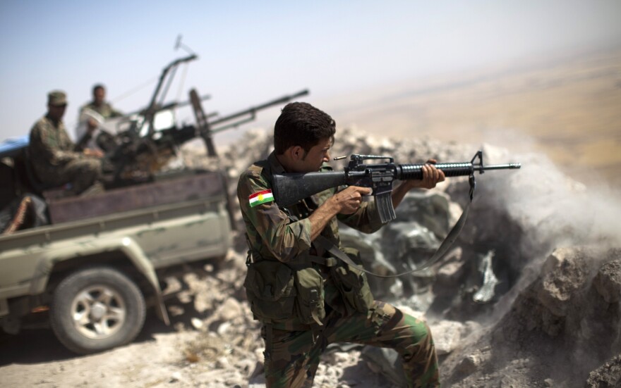 An Iraqi Kurdish peshmerga fighter fires at Islamic State militants from his position on Mount Zardak, Iraq, on Tuesday. Kurdish forces in northern Iraq have worked with the U.S. military, which has been bombing Islamic State positions from the air.