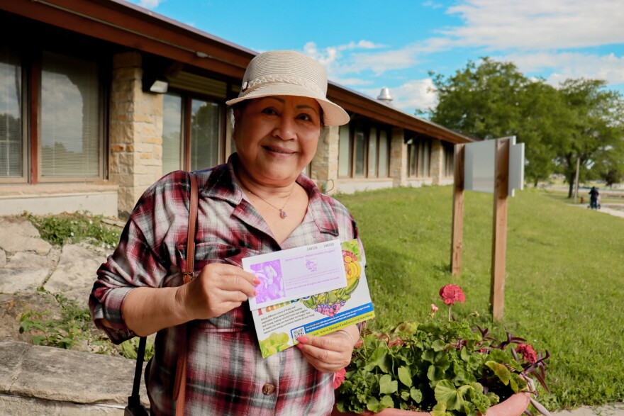 Participant picking up her farmers market voucher
