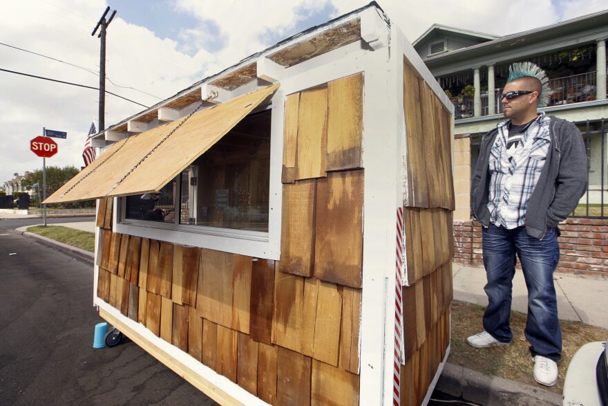 Los Angeles resident Elvis Summers poses with his tiny house on wheels he built for a woman who had been sleeping on the streets in his South Los Angeles neighborhood on Thursday, May 7, 2015.