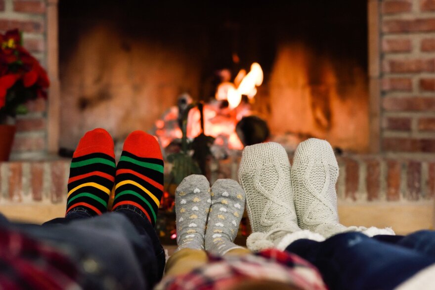 A family enjoys a fire in a fireplace