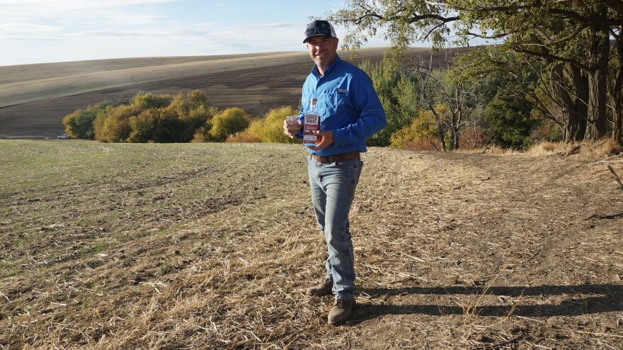 Nathan Rea holds a bottle of the first Salmon-Safe American single malt whiskey. Rea grew the barley used to make the whiskey in Walla Walla.