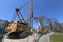 Workers prepare a diesel hammer to drive an H-pile into the ground on the southeast side of the Sagamore Bridge, adjacent to the former Christmas Tree Shops, to test the pile's performance in local soil and bedrock for a bridge foundation. Although testing is starting on the east side of the bridge, the new Sagamore Bridge will be build on the west side.