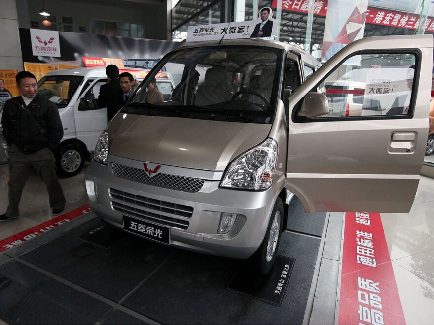Visitors look at minivans at a GM joint venture dealership in China. GM and its partner, Wuling, sold more than 560,000 of their Sunshine minivan in China last year.