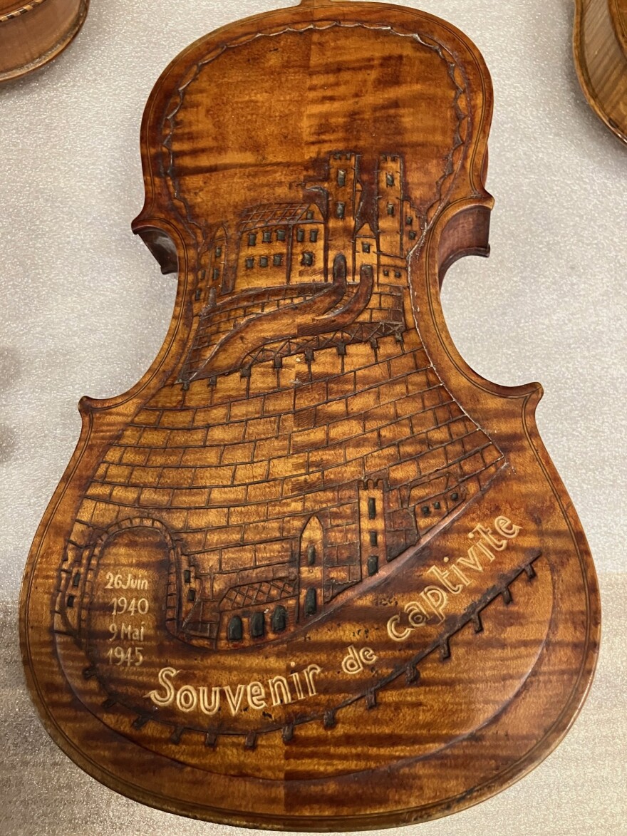 A French violin that's part of the QC exhibit, carved to include "souvenir of captivity," and dates that France was occupied by Nazi Germany, between 1940 and 1945.
