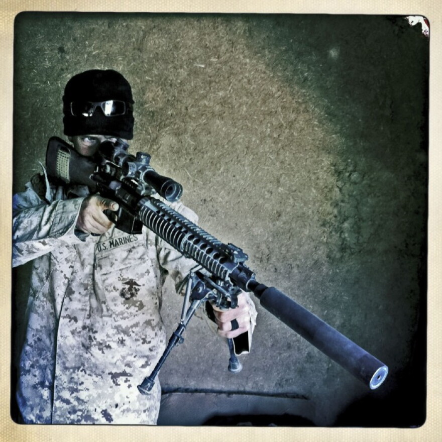 A U.S. Marine from Battalion 1/8 inspects the optics of his rifle on Patrol Base Talibjan in Helmand province, before going on an operation on Jan. 21.