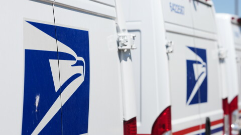 FILE - Delivery vans are parked during a protest staged as part of a countrywide National Day of Action Tuesday, July 28, 2026, outside the main United States Postal Service headquarters in northeast Denver.