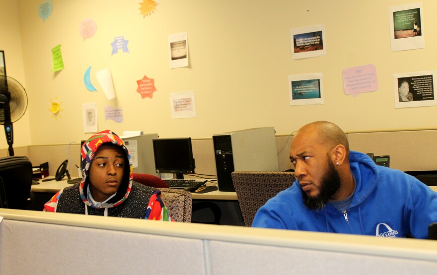 St. Louis Public Schools curriculum instructor Sylvester McClain, right, talks with student Jaevon Gill at Workforce High School.