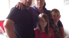 Travis Finkenbinder stands with his wife Samantha, daughter Alyssa and son Taylor. This photo was taken in early June 2014, before he suffered severe head trauma. (Photo Courtesy of Samantha Finkenbinder)