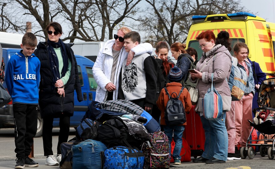 Olya Kachan and Maxim Zyabkin, who fled from the city of Kherson, embrace as they wait to load up on a bus that will take them to Poland from the central train station on April 15, 2022 in Lviv, Ukraine.