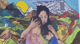 A mural depicting a mother holding two children is painted on the side of the Center for Immigrant and Refugee Advancement building in Omaha on Dec. 5, 2025. The artwork reflects themes of family separation and protection central to many immigration cases.