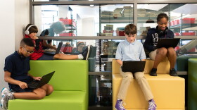 Students at John Rex Charter Middle School in Oklahoma City – sixth graders Finley Cunningham, top left, Direon Kelley, bottom left, Charlie Marshall and Taylor Ellis – sit on cushions in the hallway during a break from schoolwork.