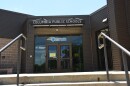 A view of the entrance to Columbia Public Schools. Stairs and railings leading up to the doorway are visible at the front of the image. 