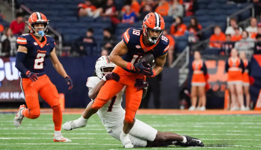 Oronde Gadsden (19, blue) breaking a tackle