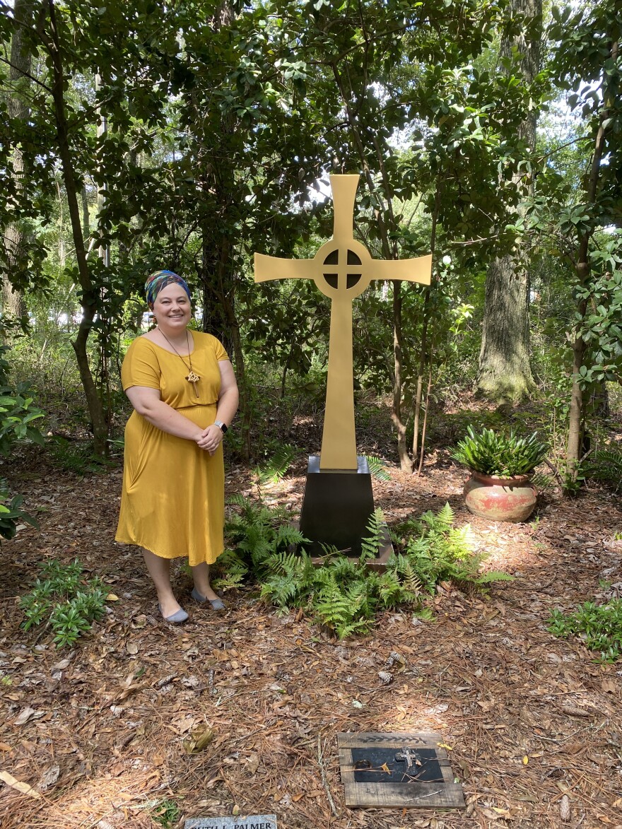 Rev. Rebecca Putman, of Westminster Presbyterian Church, stands next to the cross that overlooks the memorial garden. Putman said members of the congregation use the space to honor those who have passed. (Kai Johnsen/WUFT News)