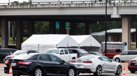 Cars line up for CommUnityCare's drive-thru COVID-19 testing at Hancock Center.