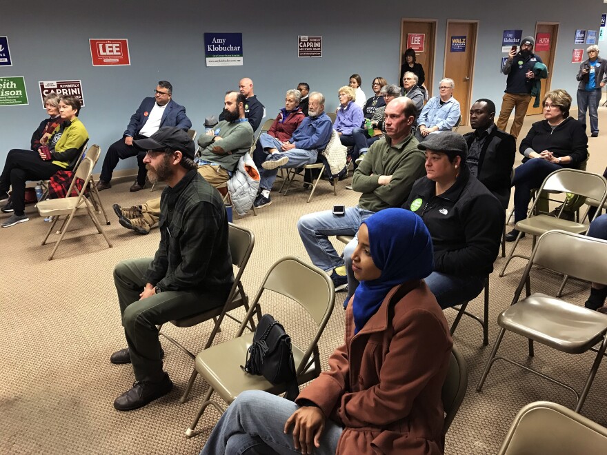 Ilhan Omar (lower right) sits with a crowd of volunteers and Democratic Farmer Labor party members.