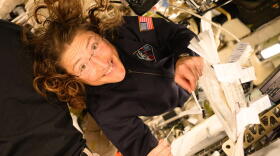 NASA astronaut Christina Koch smiles at the camera as she holds a pipette and saliva booklet for the Artemis II Immune Biomarkers study. Samples will be analyzed for proteins, enzymes, and other biomarkers that monitor immunity, inflammation, nutritional status, bone health, and radiation effects, to determine how crewmembers adapted to deep spaceflight conditions.