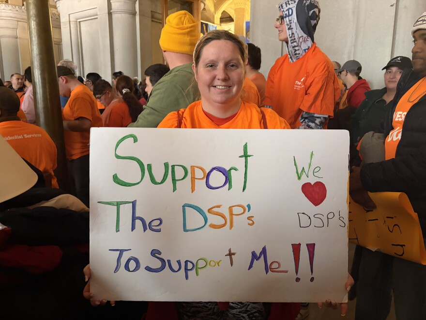 A disability advocate at the rally holds up a sign about supporting DSPs. (Direct Supprot Professionals) 