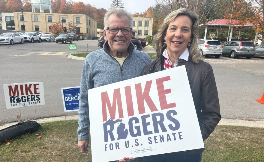 Two Mike Rogers supporters John and Cheryl Sowash outside of a campaign event hosted by the Northern Michigan Chamber Alliance in Traverse City on Friday, Oct. 23, 2026.