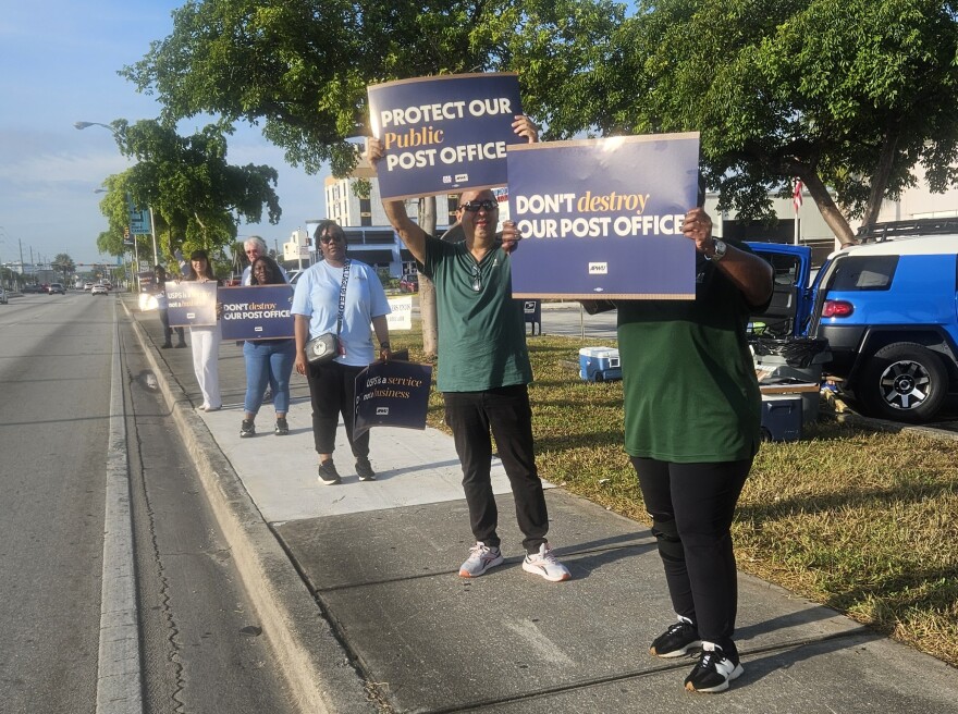 Postal workers in South Florida and across the United States staged a protest Tuesday, July 28, 2026, demanding increased public funding and legislative protections for the U.S. Postal Service. As part of the "National Day of Action to Protect our Post Offices," members of the American Postal Workers Union (APWU) Local 172, joined with labor leaders from the South Florida AFL-CIO, for a demonstration at the Norland Branch Post Office, 18640 NW 2nd Avenue, Miami.