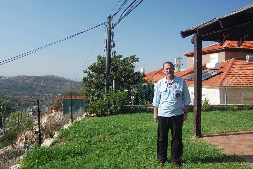 Danny Hirshberg, standing outside his home in a West Bank settlement, disagreed with Rabin's policies but helped organize this year's gathering in his memory.