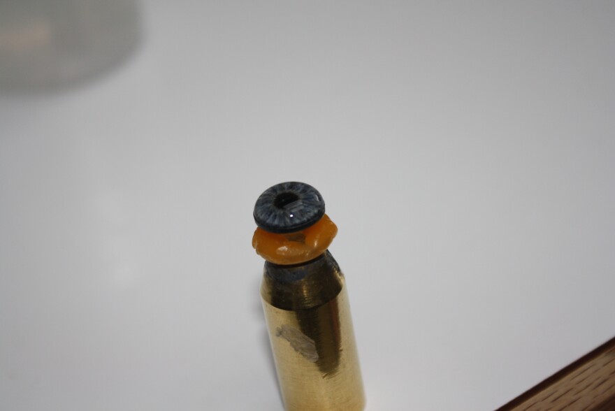 A prosthetic eye sits and dries on a stand