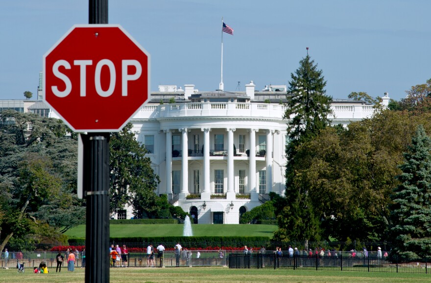 The White House is seen behind a stop sign in Washington, D.C, on Oct. 1.