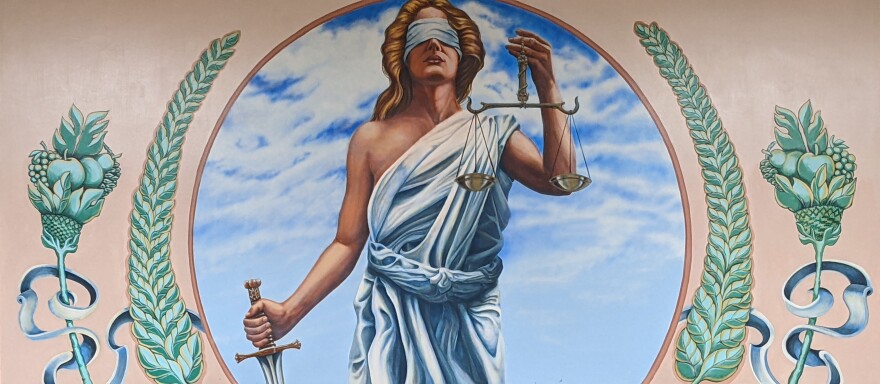 A painting of Lady Justice, blindfolded with a sword in her right hand and scales in her left.