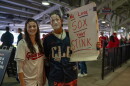 Fans in makeup with a sign that reads "We love sox that stink."