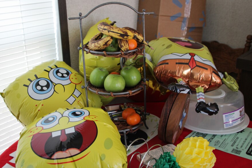 SpongeBob SquarePants balloons and fresh fruit rest on a table belonging to a family that immigrated from Costa Rica to Kansas City. The family is pursuing asylum, hoping it will provide a legal avenue for them to live and work peacefully in the United States.