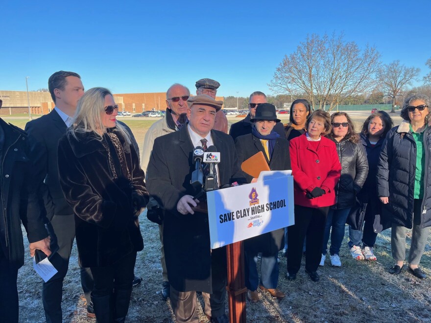 Sen. Linda Rogers, dressed in red, pictured at a December 2023 press conference organized by charter school owner Larry Garatoni, in his efforts to acquire the recently closed Clay High School for a new charter school.