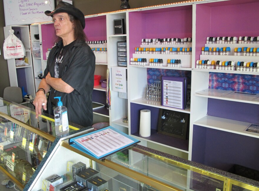 Vapor Shop employee John Talmage talks to customers. The price of the liquid nicotine used for e-cigarettes could triple under Gov. Kasich's budget proposal.