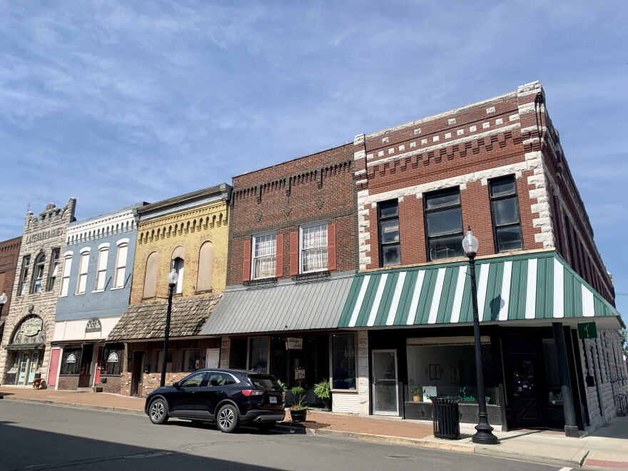 The view of a few shops in downtown Mexico, Missouri. The buildings appear older with unique facades of different colored brick. 
