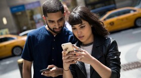 Left to right: Sameer Uddin and Michelle Macias play Pokemon Go on their smartphones outside of Nintendo's flagship store, July 11, 2016 in New York City.  The success of Nintendo's new smartphone game, Pokemon Go, has sent shares of Nintendo soaring. (Drew Angerer/Getty Images)