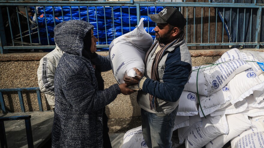 Displaced Palestinians receive food aid at the United Nations Relief and Works Agency for Palestine Refugees center in Rafah in the southern Gaza Strip on Sunday.