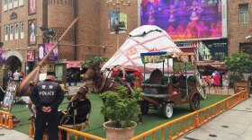 At Urumqi's Grand Bazaar, a police officer chats with a local vendor while a video promoting China's ethnic minorities plays on a big screen overlooking the square. This was the site of Uighur protests in 2009 that sparked citywide riots, leading to the death of hundreds. Since then, the city has become one of China's most tightly controlled police states.