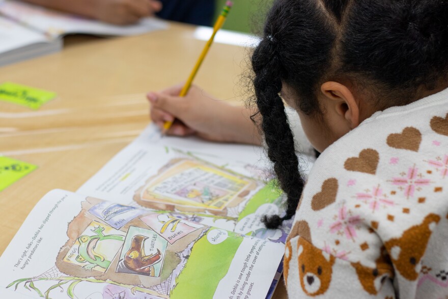 A student at Tulsa Public Schools writes in a workbook during English Language Arts instruction.