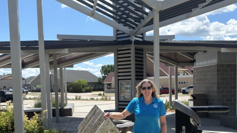 Erin Reed, executive director of the Dickinson County Trails Board, stands at a trailhead in Spirit Lake, Iowa, in June 2026. (Bret Hayworth, Siouxland Public Media News)