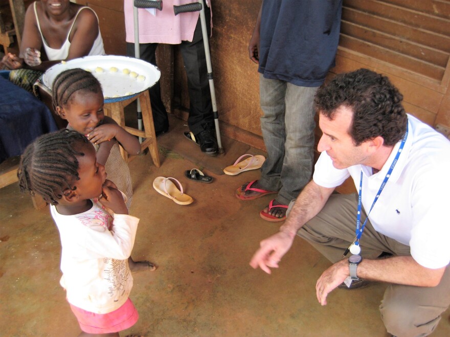 Dr. Paul Spiegel greeting children displaced by conflict in Côte d'Ivoire while undertaking an assessment mission in 2017.